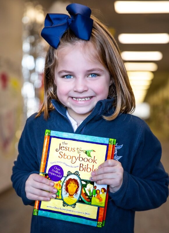 Girl holding her free book from Little Knights Book Club